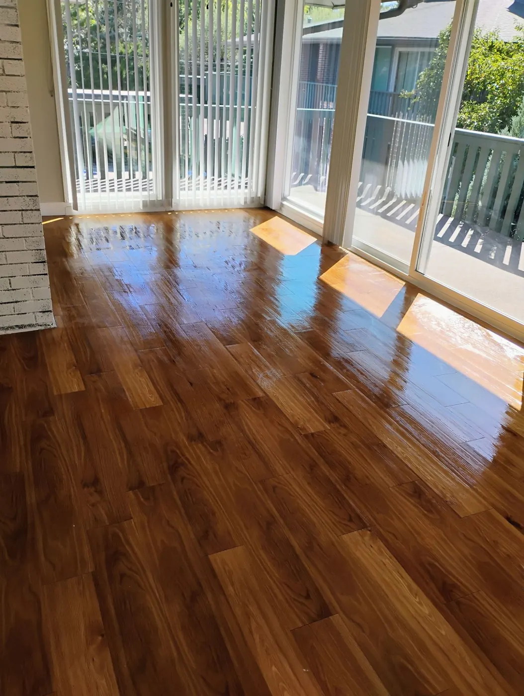 Sunlit living room with freshly cleaned, glossy hardwood floors